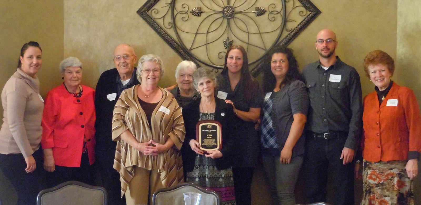 Jo Tolck with Herkenhoff family members. Left to Right: Meghan Habisch (daughter), Barb Herkenhoff (sister-in-law), Ray Herkenhoff (brother), Kathy Herkenhoff (Art’s wife), Lorraine Peterson (sister), Jo Tolck, Mary Mattheison (daughter), Nikki Herkenhoff (daughter-in-law), Joe Herkenhoff (son) and Colleen Perfect, President of CPO.